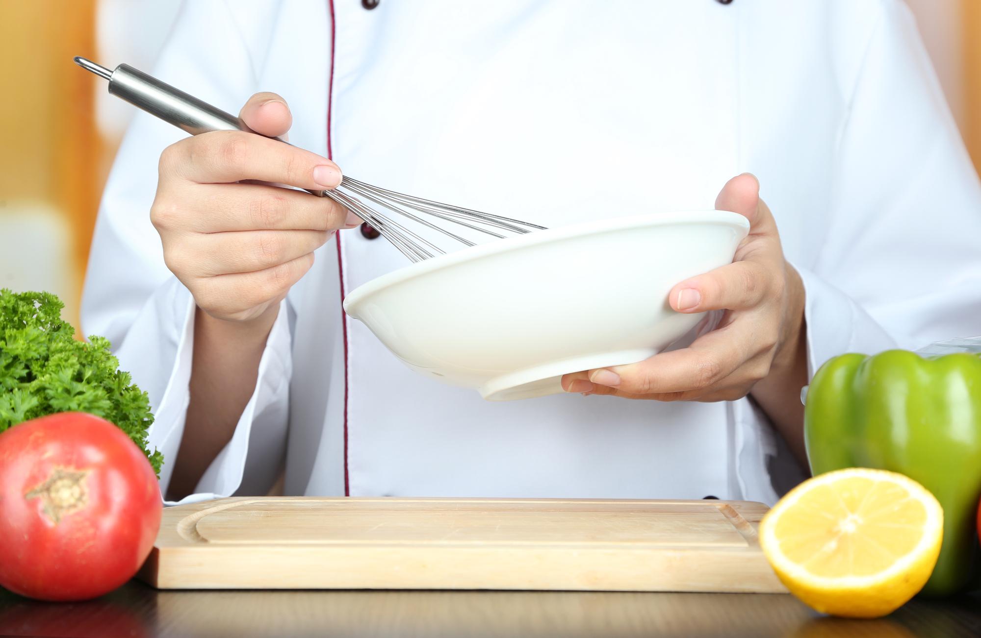 Chef che prepara una ciotola di ingredienti freschi in cucina